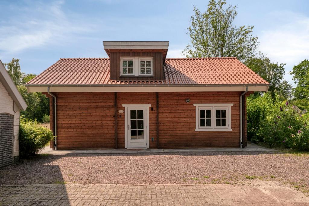 a small brick house with a red roof at Luxe, rust en ruimte bij de Veluwse Vogels in Epe in Epe