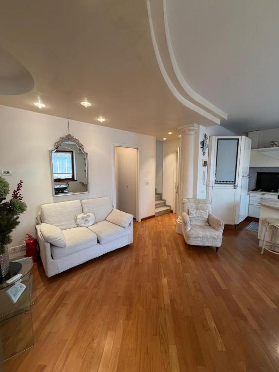 ein Wohnzimmer mit einem weißen Sofa und einem Sessel in der Unterkunft Sottocastello 2 in Gorizia
