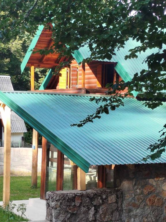 a house with a tin roof on top of it at Vikendica Veruša in Veruša