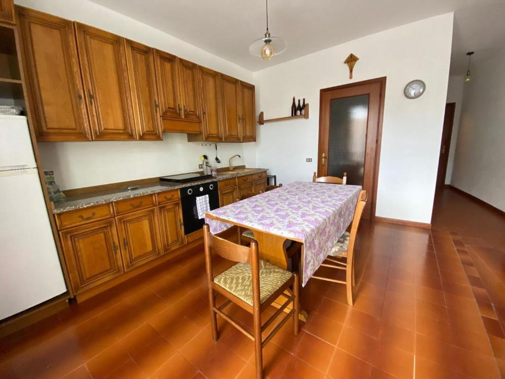 a kitchen with a table and wooden cabinets at Dormire a Valgoglio Baita della Diga in Valgoglio