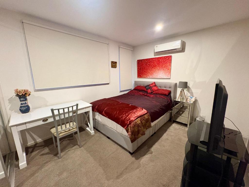 a bedroom with a bed and a desk and a tv at Spacious Master Room with Private Ensuite in Melbourne