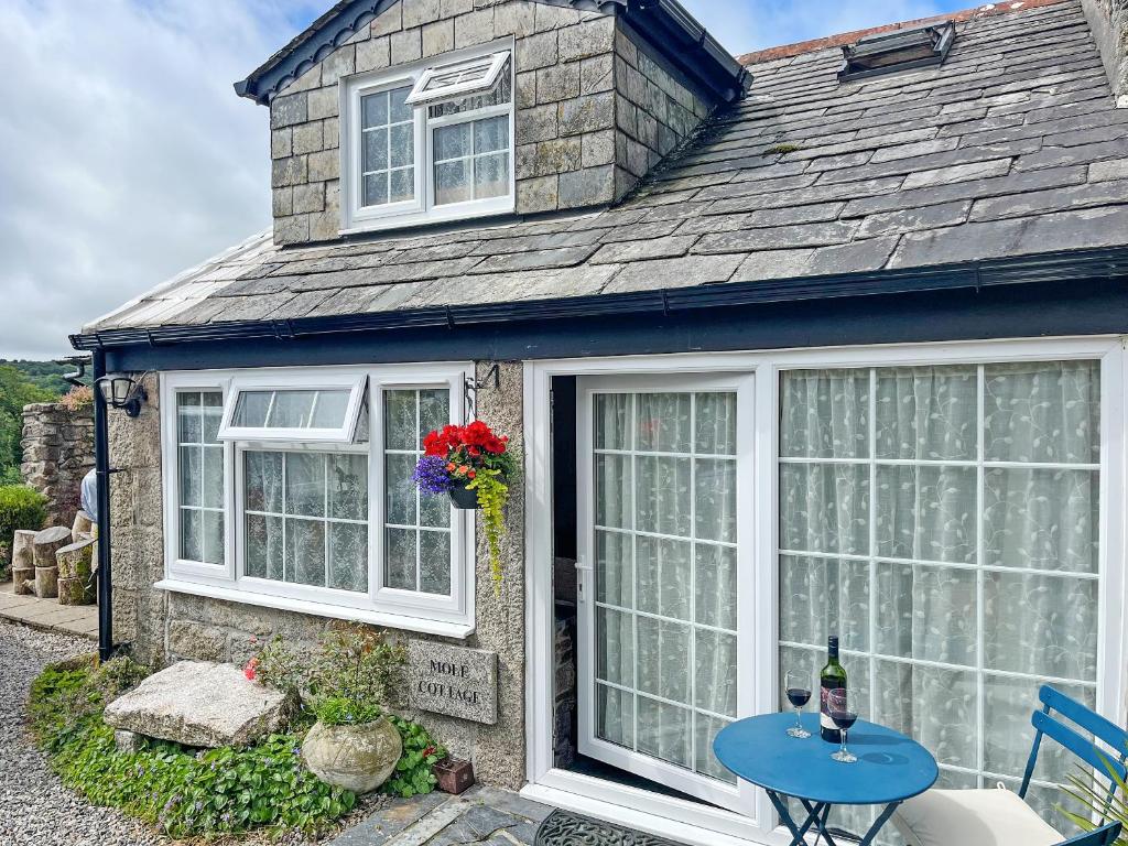 a house with white windows and a blue table at Mole Cottage - Uk52139 in Liskeard