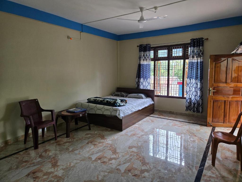 a bedroom with a bed and a table and chairs at Sharma Residency in Dithur