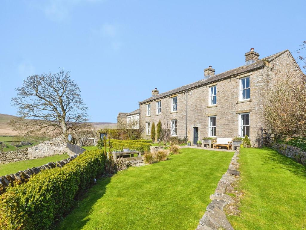 an exterior view of a large stone house with green grass at Low Seal House in Richmond
