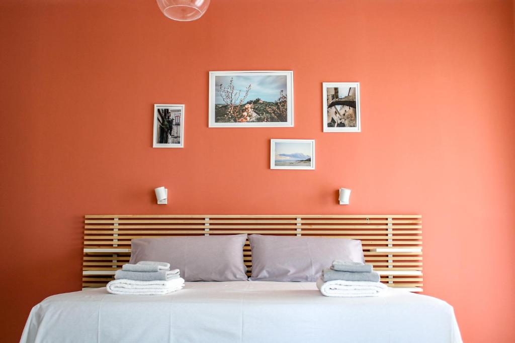 a bedroom with an orange accent wall and a bed at Magna Grecia B&B e Appartamenti in Caulonia Marina