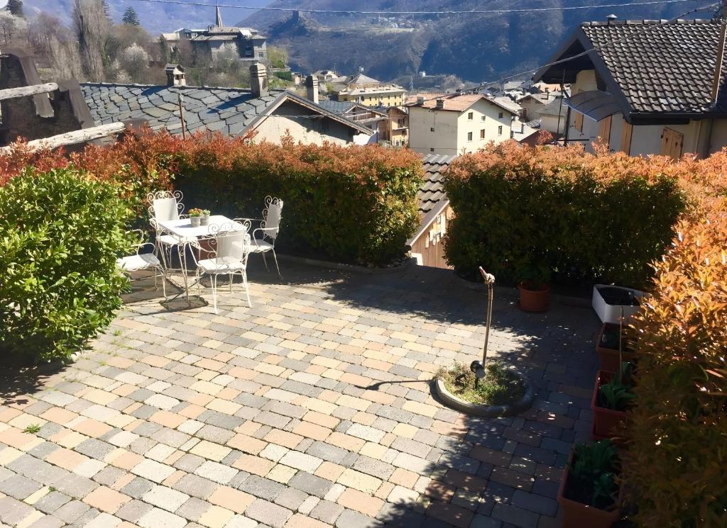 a patio with a table and chairs in a garden at A Casa di Zia Renny in Châtillon