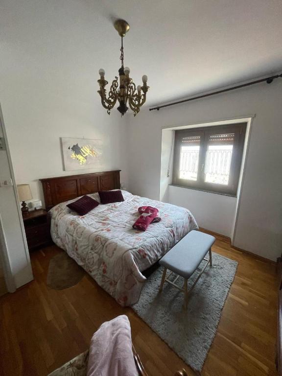 a bedroom with a bed and a chair and a chandelier at A Casa di Zio Zeffy in Châtillon