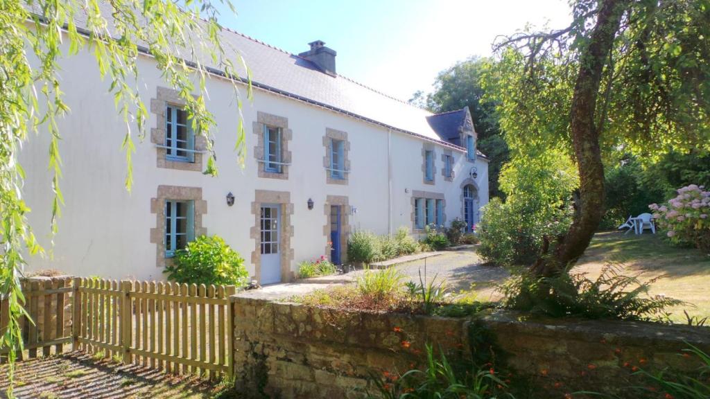 a white house with a fence and trees at Ti Bleunv-nevez in Moëlan-sur-Mer