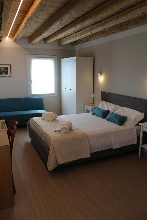 a bedroom with a large bed and a blue couch at Cà Dei Nonni in Castelfranco Veneto