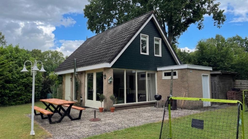 a small house with a picnic table in front of it at Huisje 47 | 8 persons in Gasselte