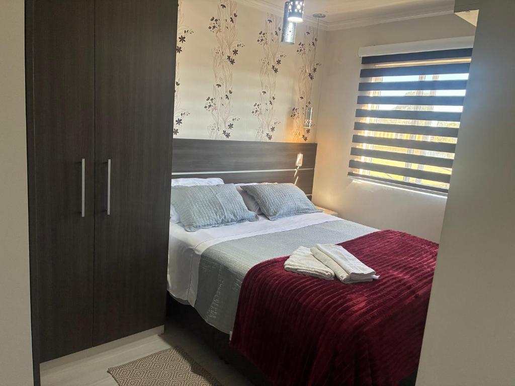 a bedroom with a large bed with a wooden cabinet at Apto completo 2 quarto 2 banheiro universidade Positivo Volvo C garagem in Curitiba