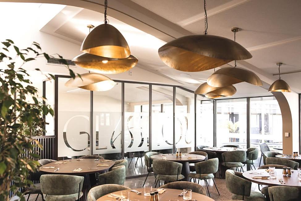 a restaurant with tables and chairs and large windows at The Avenue in Whanganui