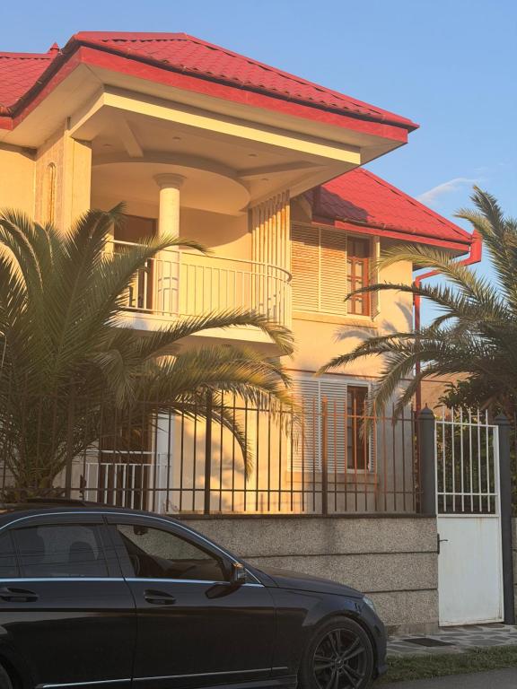 a black car parked in front of a house at Tinano in Kuchkisabano