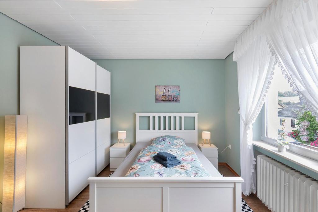 a bedroom with a white bed and a window at Landidylle – Nostalgie in Ortenberg