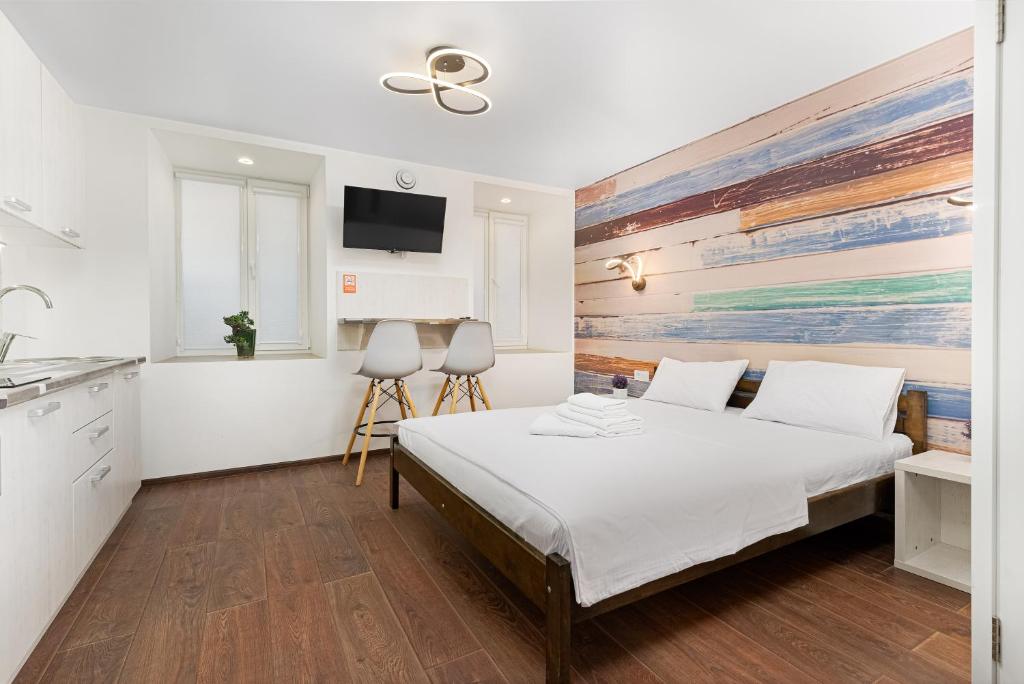 Opera Lane Suites في أوديسا: غرفة نوم بها سرير وجهاز تلفزيون معلق على الحائط