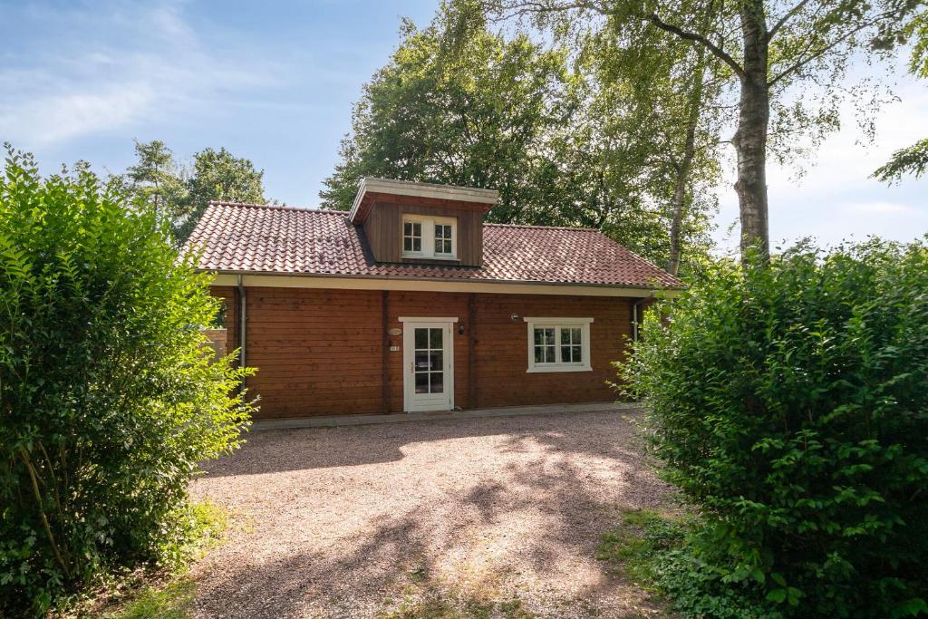 a small wooden house with a roof at Luxe, rust en ruimte bij de Veluwse Vijf in Epe in Epe