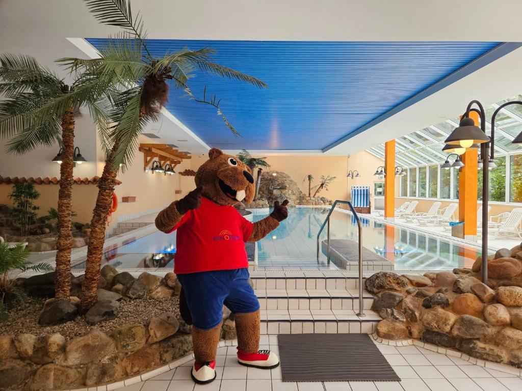 Eine Person im Bärenkostüm steht neben einem Pool. in der Unterkunft Familien Apartmenthotel Panoramic in Bad Lauterberg