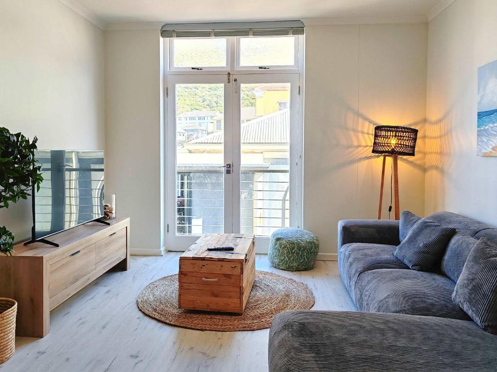 a living room with a couch and a tv at Waveside Stays in Muizenberg