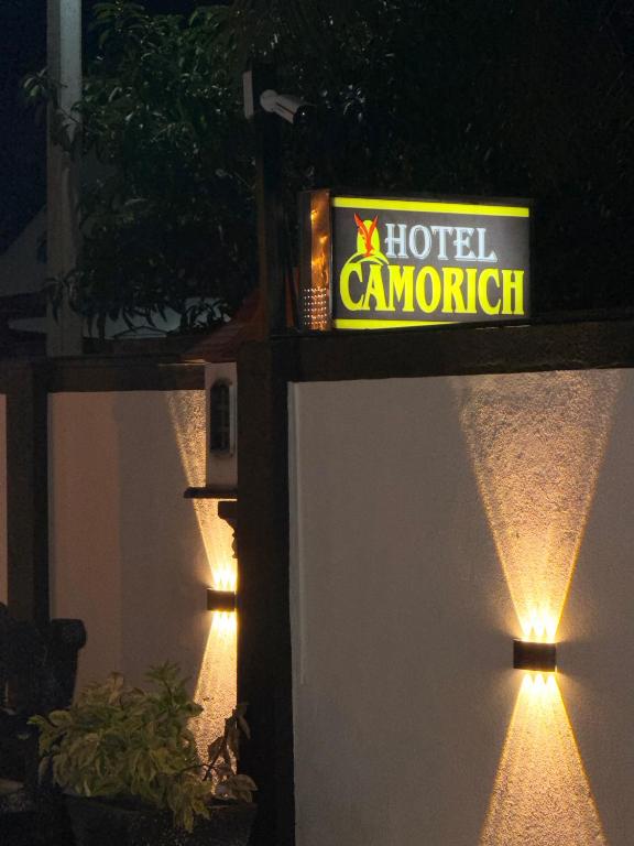 a hotel camaugh sign on the side of a building with lights at Hotel Camorich in Tissamaharama