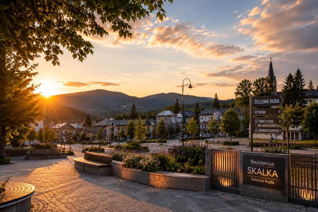 a town square with a sunset in the background at Luxury Apartments & Wellness Access in Železná Ruda