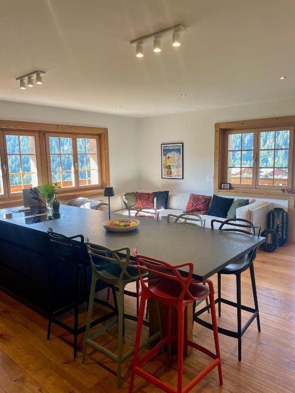 a living room with a table and chairs and a couch at 3 bedroom Modern Alpine Escape in Chateau-d'Oex