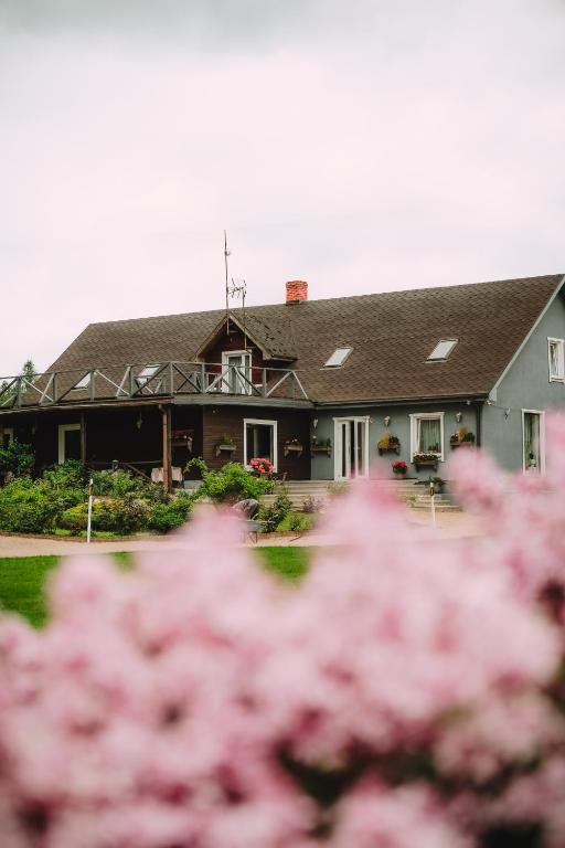 a house with pink flowers in front of it at Ēmužas in Dārte