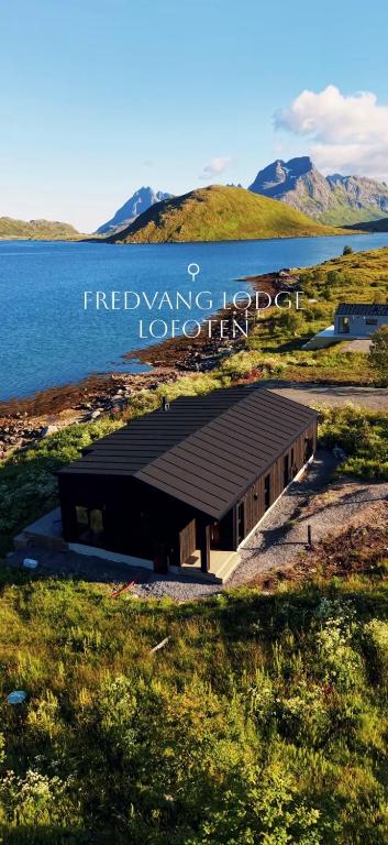 a building sitting next to a body of water at Fredvang Lodge, Lofoten in Fredvang