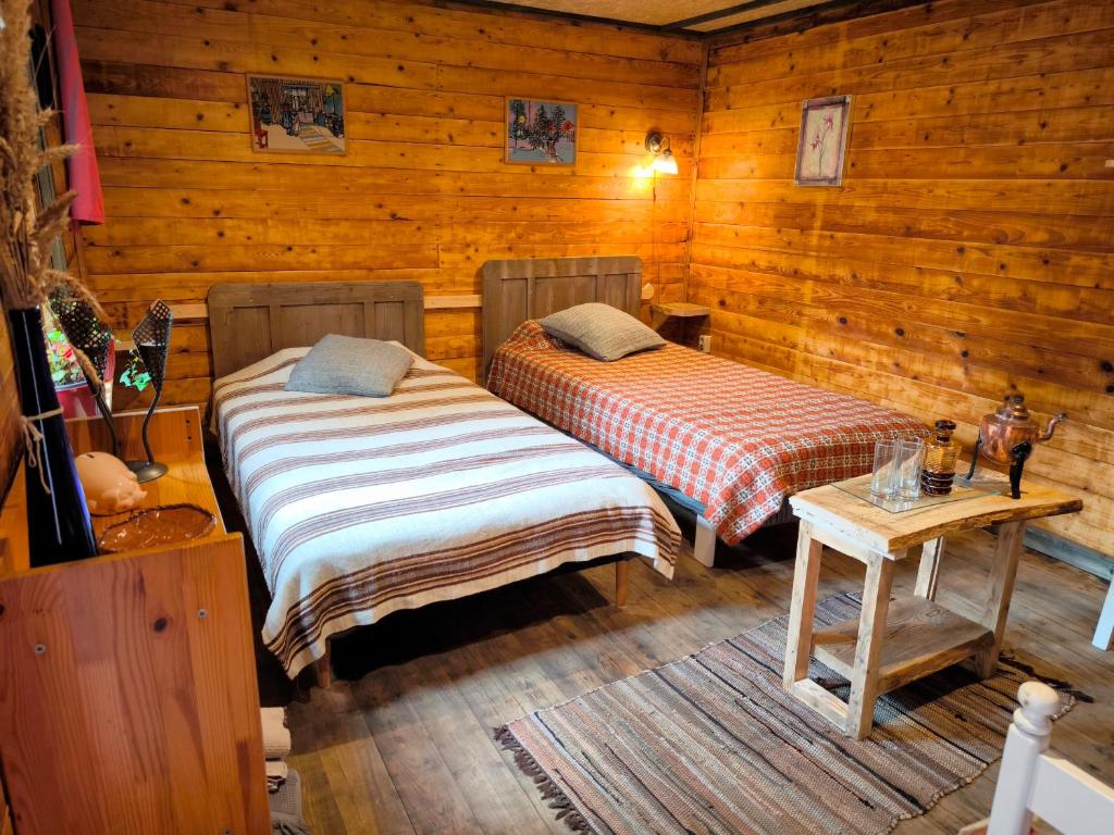 a bedroom with two beds in a log cabin at Barn Suite in Valga