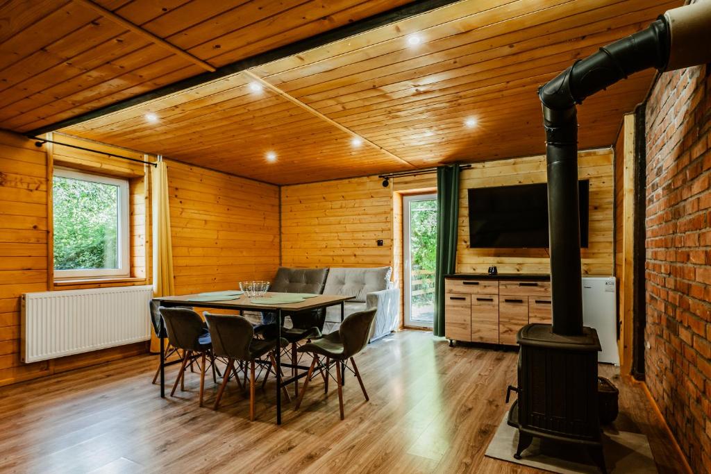 a dining room with a table and a wood stove at Stachowa Chata Guciów in Guciów