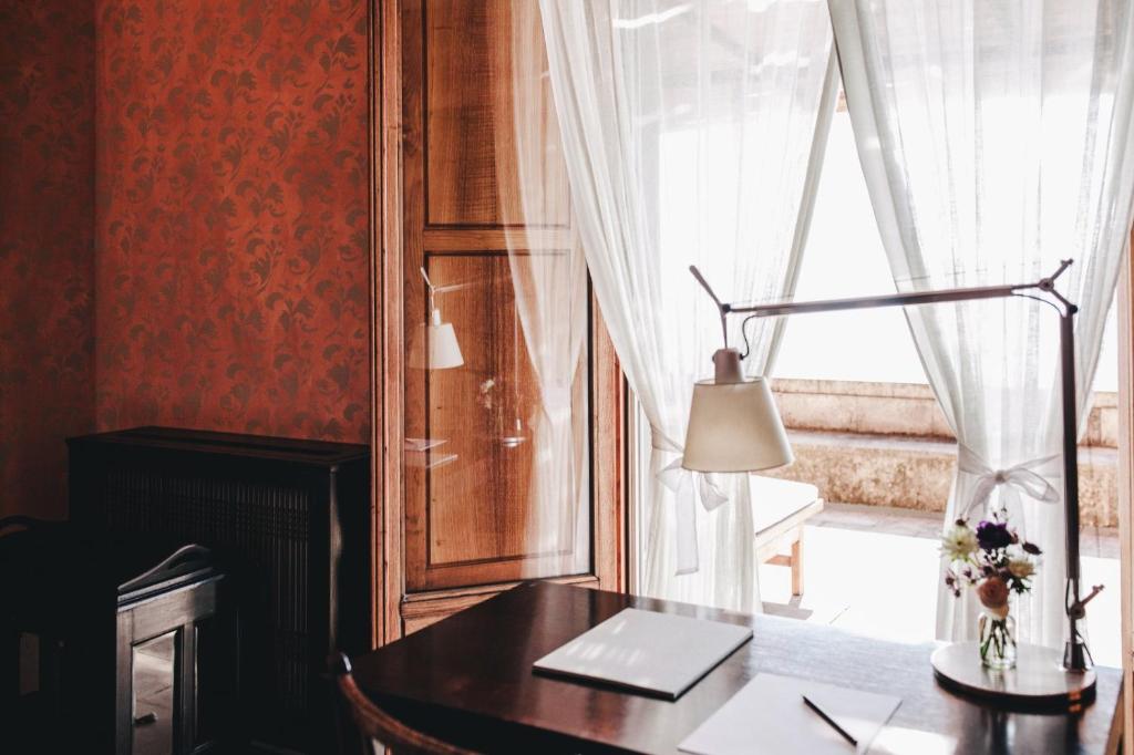 a desk with a lamp in front of a window at Mà C'a - Casa Privata in Praiano