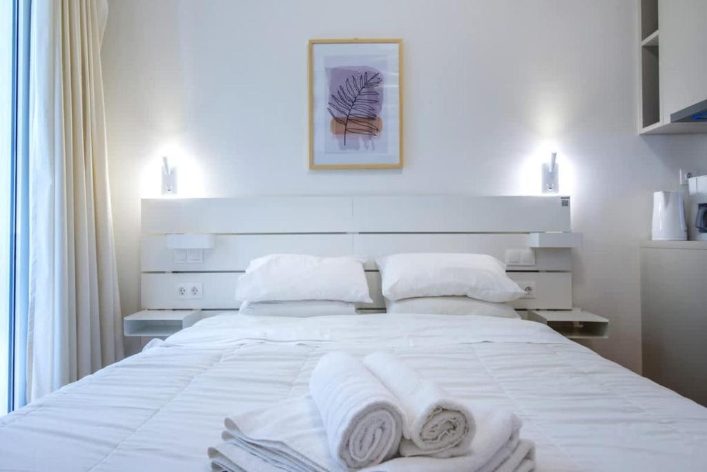 a bedroom with a white bed with towels on it at Syntagma Gem 1 in Athens