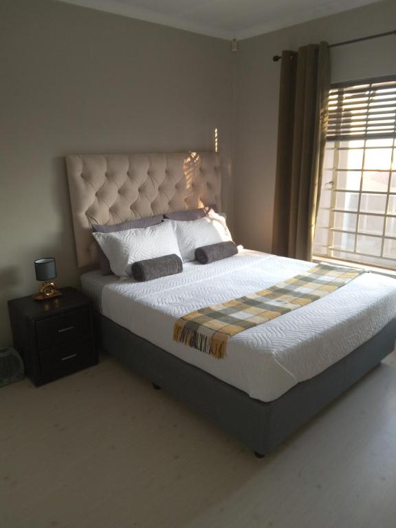 a bedroom with a large bed and a window at Nested at L&MX in Centurion
