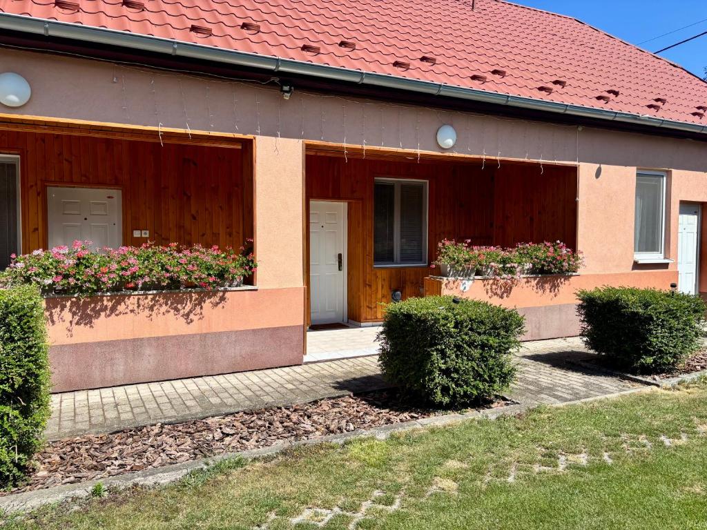 a house with a red roof and some bushes at Ubytovanie Klára in Veľký Meder