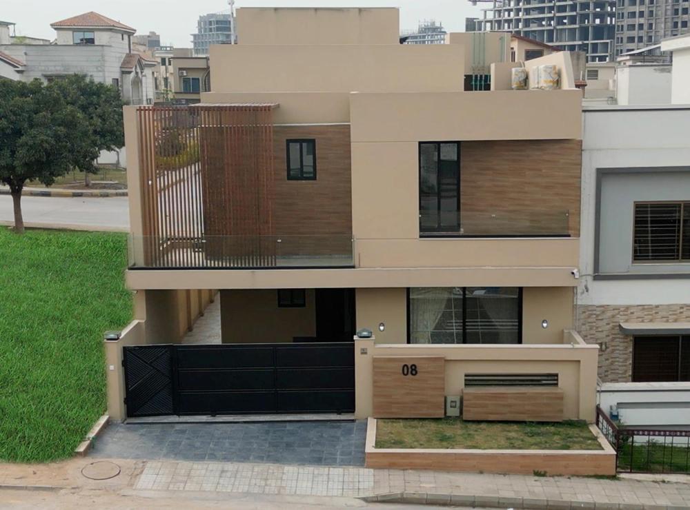 a house with a black gate and a balcony at House in Lahore