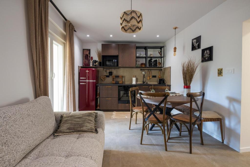 ein Wohnzimmer mit Tisch und Stühlen und eine Küche in der Unterkunft Mamba Apartment in Sinj
