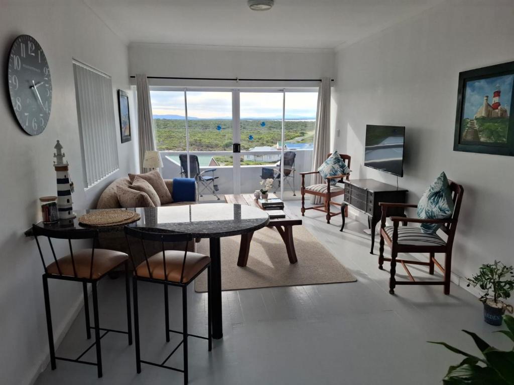 ein Wohnzimmer mit Tisch und Stühlen in der Unterkunft Top Deck in Struisbaai