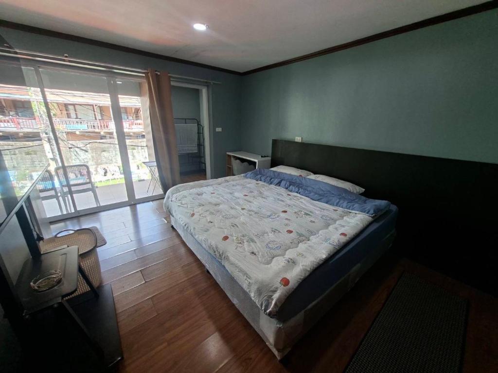 a bedroom with a bed and a large window at Baan Mo in Ban Kata