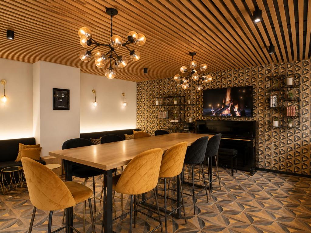 a dining room with a table and chairs and a fireplace at Logis Hotel Center in Brest