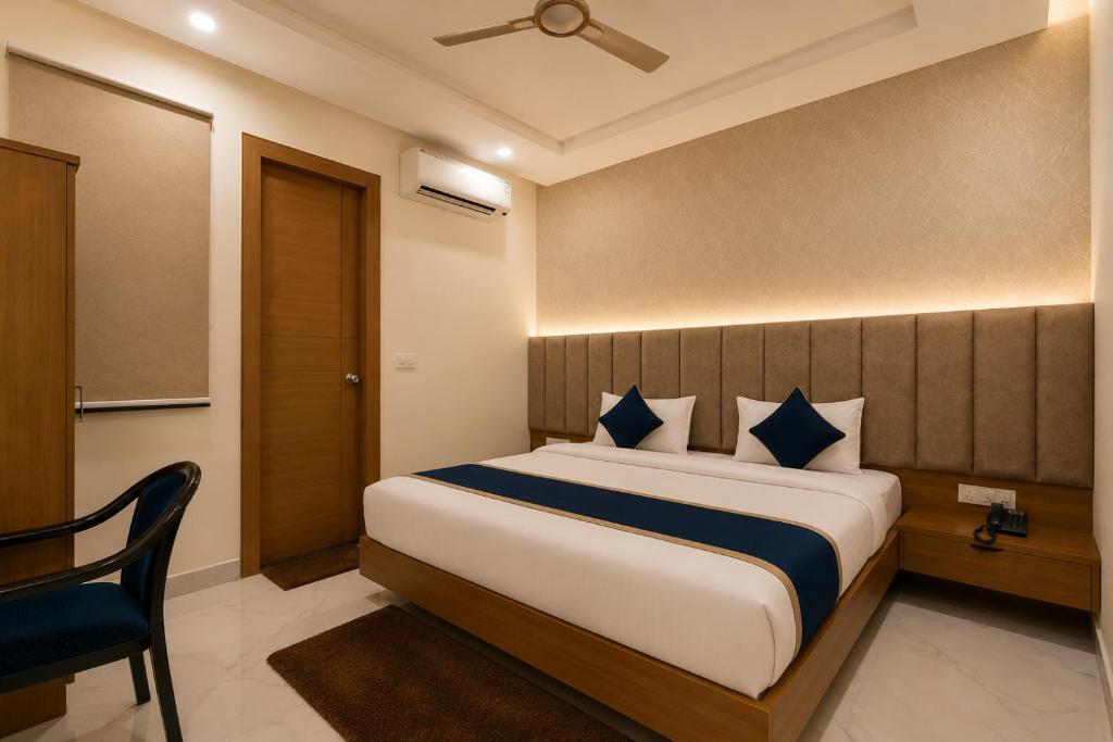 a bedroom with a bed and a chair in a room at Hotel Shree Near Prem Mandir in Chhatikara