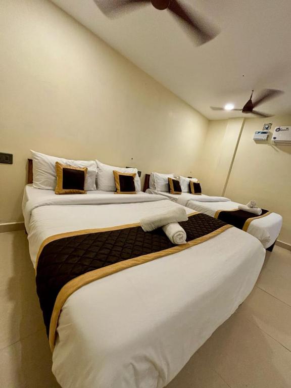a row of three beds in a room at Villa Stay in Pondicherry
