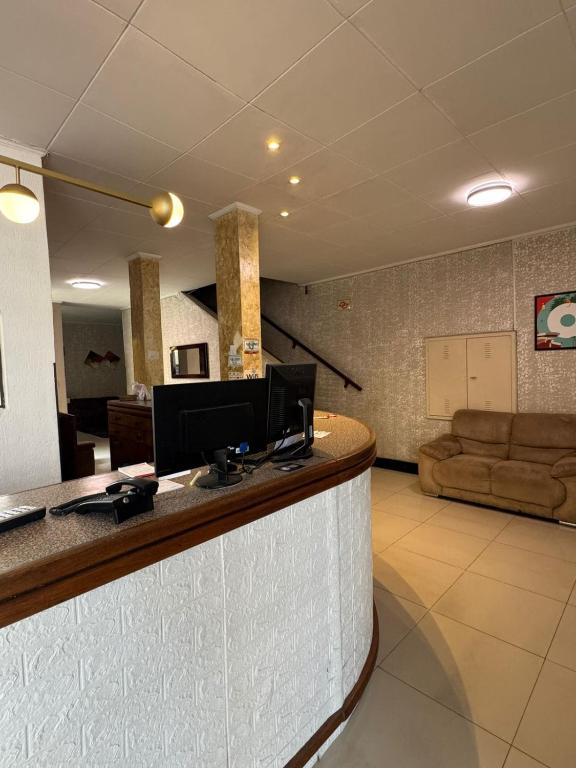 a hotel lobby with a bar with a couch at Hotel Lisboa II in São José dos Campos