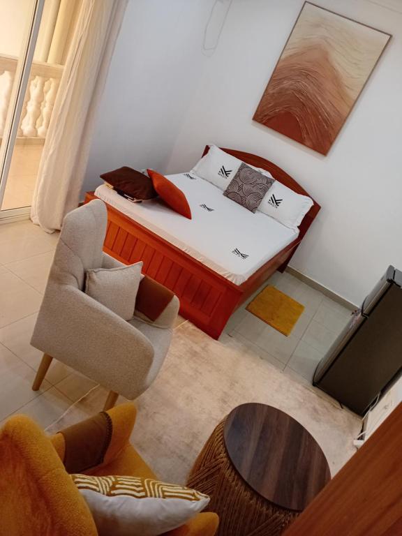 a small bedroom with a bed and a chair at Cosy Masta 1 in Pointe-Noire