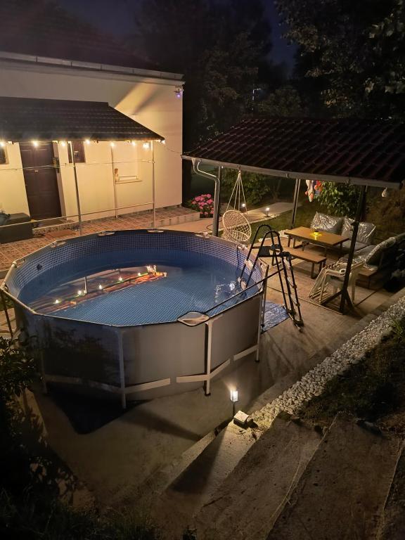 a large hot tub in a backyard at night at Apartman - kuca za odmor Slatina in Vrnjačka Banja