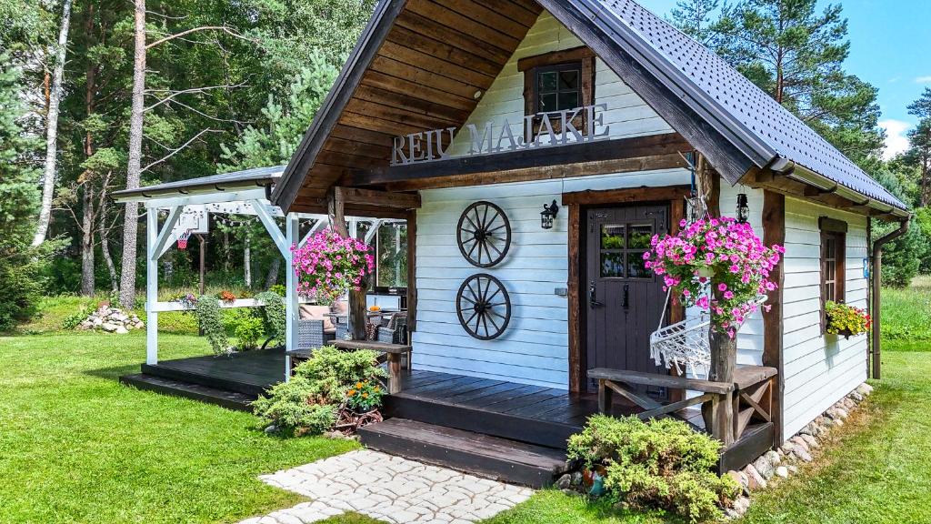 a small white cottage with a porch and a door at Reiu majake in Reiu