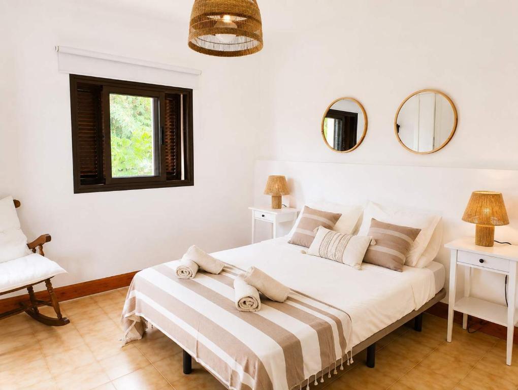 a white bedroom with a bed and two mirrors at Casa del Parque Tacoronte Centro in Tacoronte