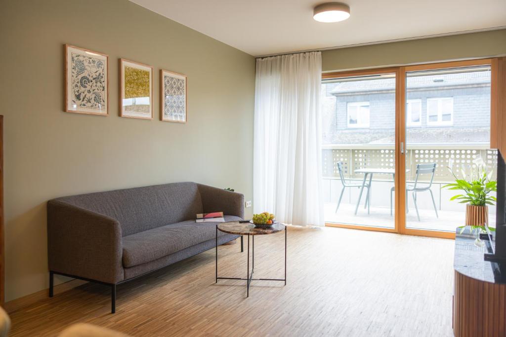 a living room with a couch and a table at Résidence du Lys - Perrin Apartments in Luxembourg