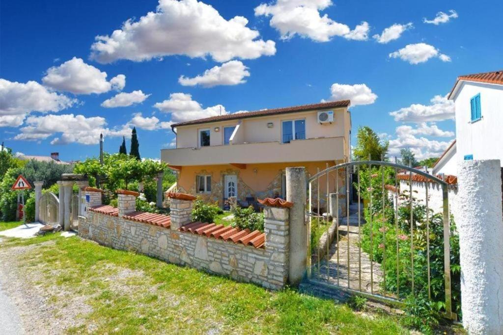 a villa with a gate in front of a house at Apartman Mara in Pomer