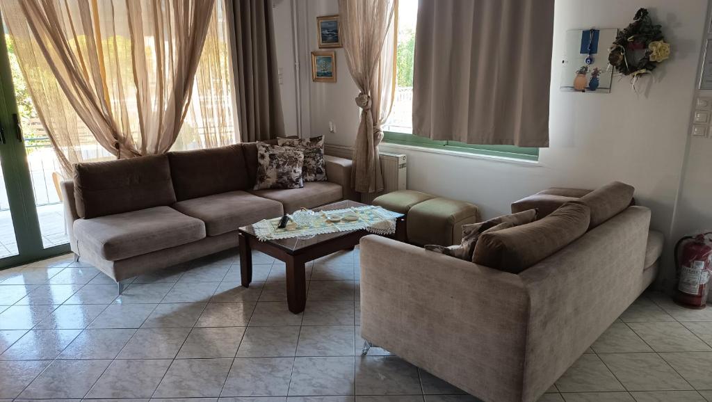 ein Wohnzimmer mit zwei Sofas und einem Couchtisch in der Unterkunft Hotel Fotini in Kamena Vourla