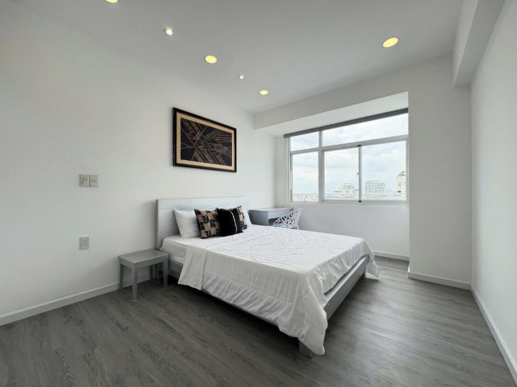 a white bedroom with a bed and a window at StayX Sky Garden in Ba Ria
