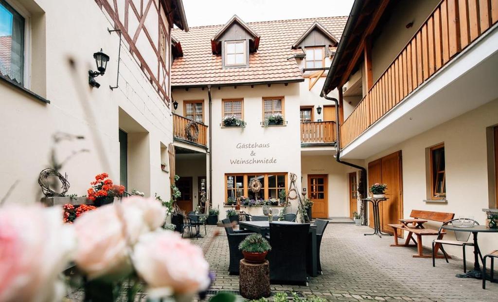 a courtyard of a building with tables and chairs at Gästehaus am Westtor in Prichsenstadt